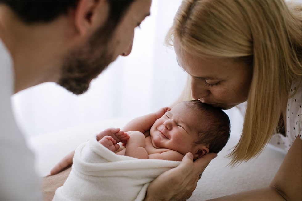 padres dando un beso a su recien nacido captado por una fotografa de barcelona