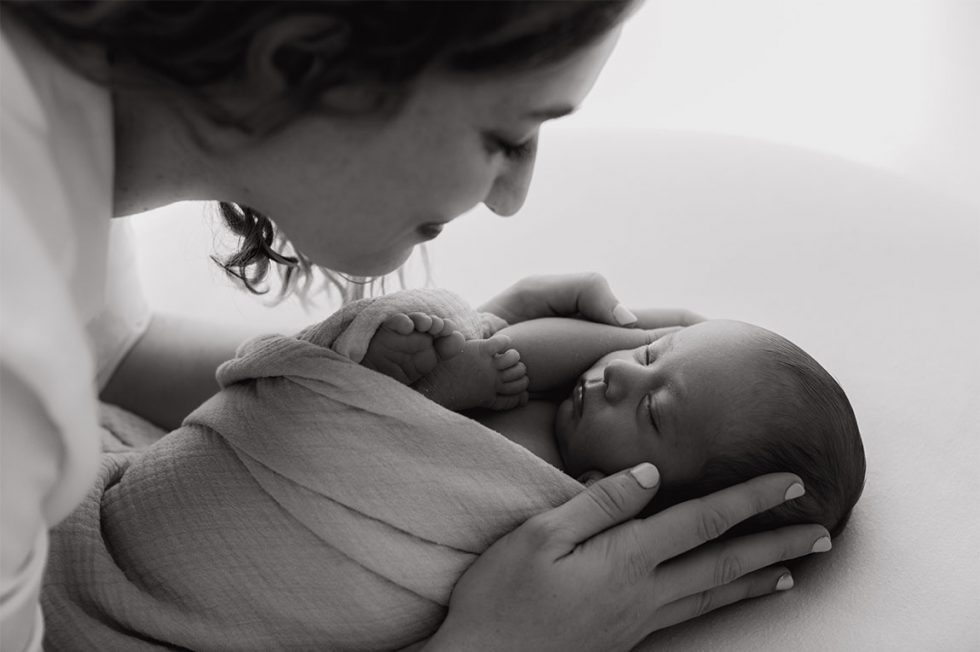 fotografia en blanco y negro de un newborn cno su madre mirandole